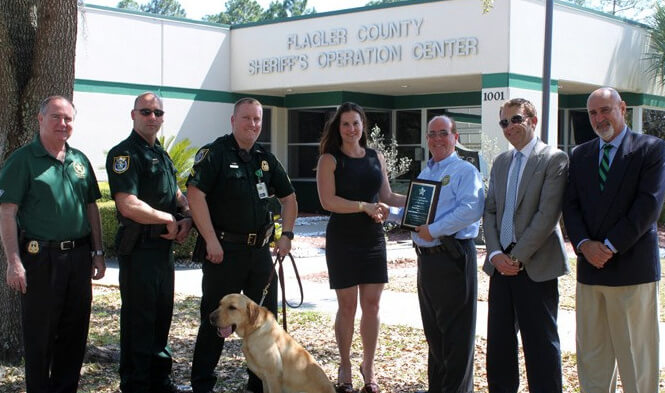 (L-R) Undersheriff Rick Staly, Commander Chris Sepe, Corporal Jon Welker and K9 Jax, Deanna Padovani-DePaco, Sheriff James L. Manfre, Honorary Consul of Portugal, Caesar DePaco, Ph.D., and Consultant Eddie Branquinho. (PHOTO/Flagler County Sheriff’s Office)